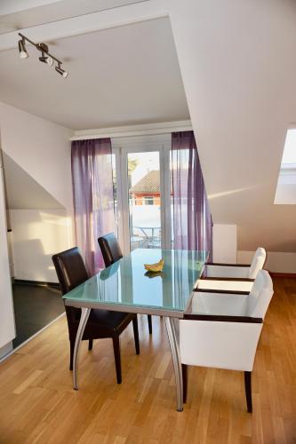 a dining room with a glass table and chairs at 3,5-Room Sunrise Terrace Haven FR-32 in Wallisellen