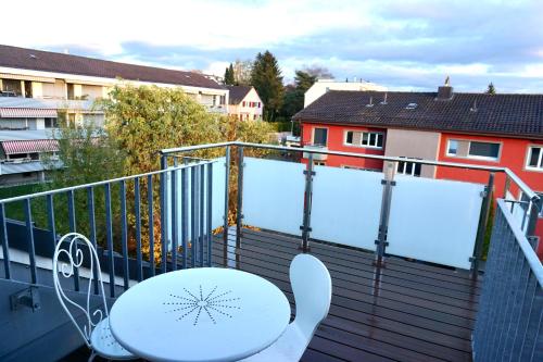 a white table and chairs on a balcony at 3,5-Room Sunrise Terrace Haven FR-32 in Wallisellen