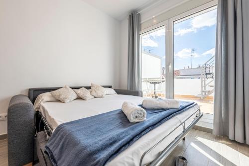 um quarto com uma cama e uma grande janela em Bettatur Apartaments Cuirateries em Tarragona