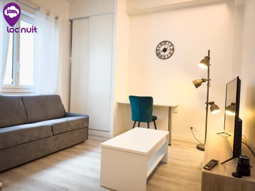 a living room with a couch and a clock on the wall at Loc'Nuit - Appartements Tout Confort - Hyper Centre AGEN in Agen