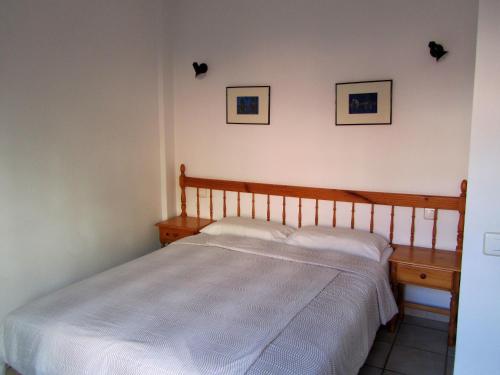 a bed in a bedroom with two pictures on the wall at Apartamentos Montecristo in Santa Cruz de la Palma