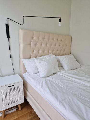 a bed with white sheets and pillows on it at Gothenburg City Apartment in Gothenburg