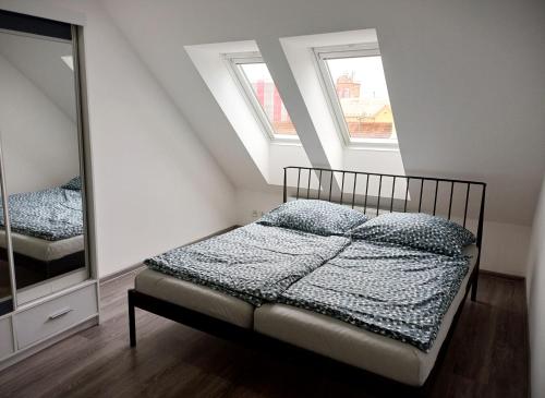 a small bedroom with a bed and a mirror at Apartmán Marty in Nové Zámky