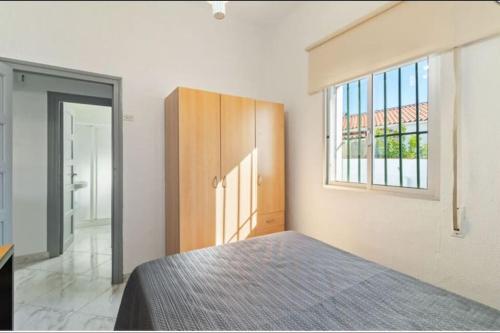 a bedroom with a bed and a window at Casa Mata cerca de Paseo Marítimo Antonio Banderas in Málaga