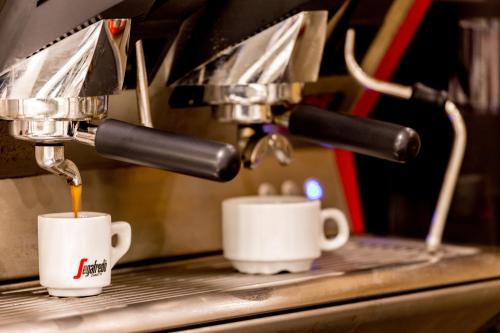 two cups of coffee are being brewed at Hotel Airmotel in Mestre