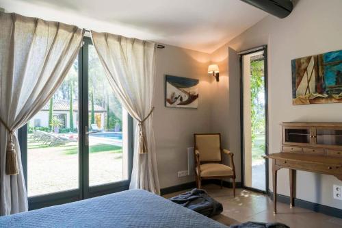 a bedroom with a bed and a desk and a window at high standard provencal bastide with heated pool in lourmarin in the luberon, vaucluse. 10 people in Lourmarin
