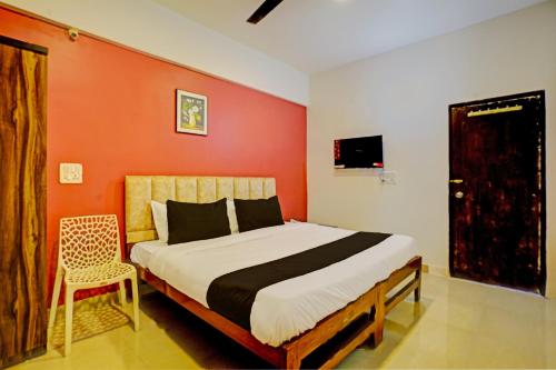 een slaapkamer met een bed met een oranje muur bij Collection O Sunset Residency in Mumbai