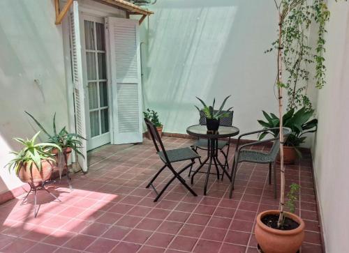 a patio with a table and chairs and potted plants at Posta belgrano excepcional en la mejor zona de Mendoza in Mendoza