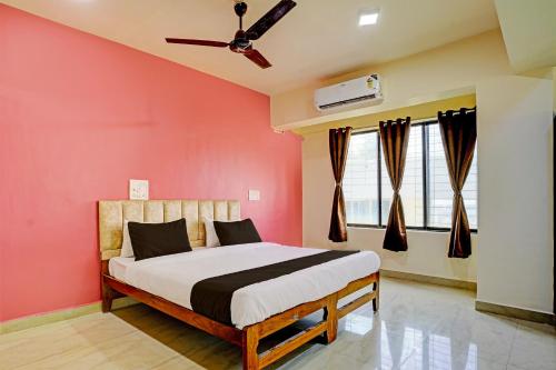 een slaapkamer met een bed en een plafondventilator bij Collection O Sunset Residency in Mumbai