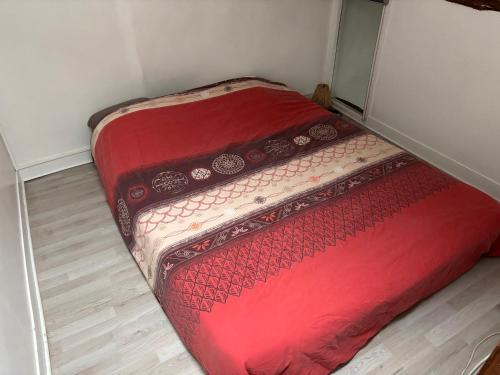 deux lits dans une petite pièce avec une couette rouge dans l'établissement Appartement atypique à deux pas du Château de Versailles, à Versailles