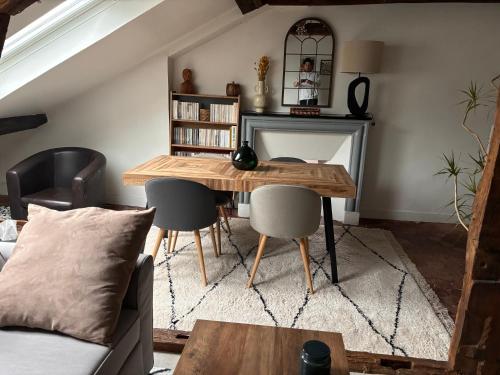 un salon avec une table et des chaises en bois dans l'établissement Appartement atypique à deux pas du Château de Versailles, à Versailles