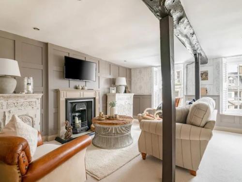 a living room with a couch and a fireplace at Howman House in Cheltenham
