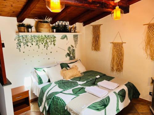 Schlafzimmer mit einem Bett mit einer grünen und weißen Bettdecke in der Unterkunft petit palais in Catania