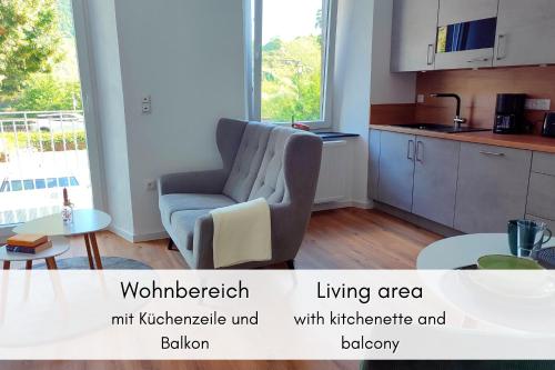 a living area with a chair and a kitchen at Moselidyll im Alten Winzerhaus am Calmont in Bremm