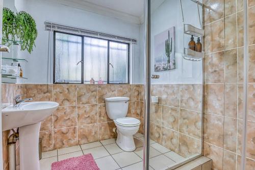 a bathroom with a toilet and a sink and a shower at The Cottage-1 Bed-pool-bbq-fibre-solar-samrand in Centurion