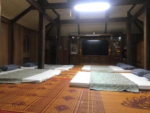 a room with a row of mattresses in front of a tv at Mai chau Horizon Homestay in Mai Chau