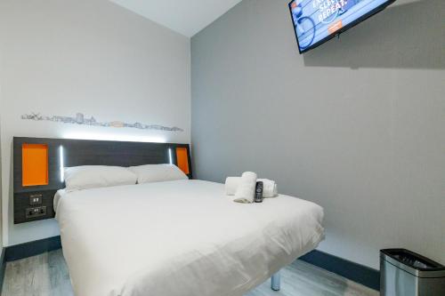 a bedroom with a white bed and a flat screen tv at easyHotel Milton Keynes in Milton Keynes