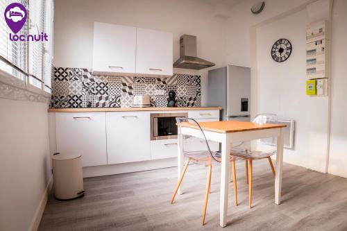 a kitchen with a table and chairs in a room at Loc'Nuit - Appartements Tout Confort - Hyper Centre AGEN in Agen