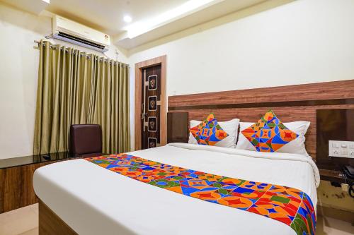 a hotel room with a bed and a television at FabHotel Raj Vihar Residency in Vijayawāda