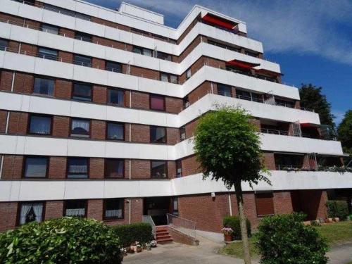 un grand bâtiment avec un arbre devant lui dans l'établissement Elbe Ferienwohnung Glückstadt Reimer Ahsbahs, à Glückstadt