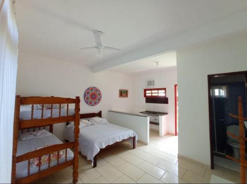ブジオスにあるPousada Arpoador de Búziosのベッドルーム1室(二段ベッド2組付)、キッチンが備わります。