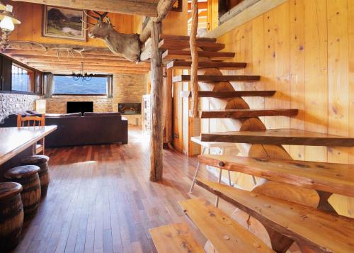 a living room with a wooden staircase in a cabin at Can Ricart in Puigcerdà