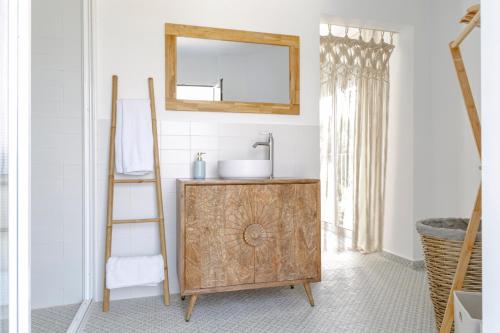 a bathroom with a wooden cabinet and a mirror at Finca de l’Anglès. Casa Mistral in Potríes