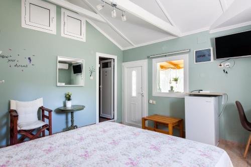 a bedroom with a bed and a tv on the wall at Garden Rooms in Fanárion
