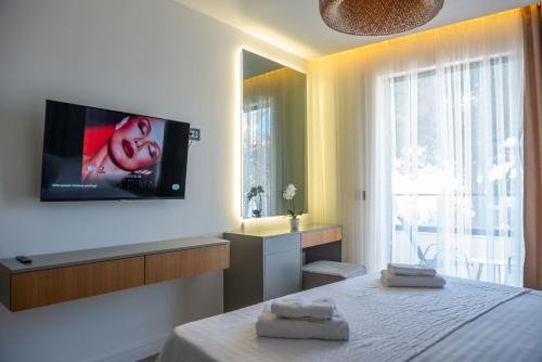 a bedroom with a bed and a tv on the wall at Botanica Boutique Hotel in Ulcinj