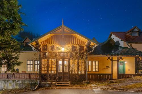 una casa con techo de gambrel por la noche en Soví Dom - Owl House, en Svätý Anton