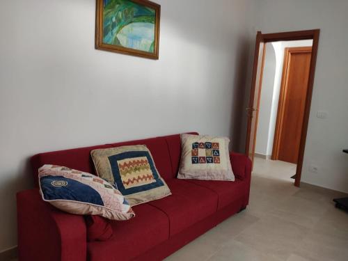 a red couch in a living room with two pillows at Tra i Parchi in Pescina