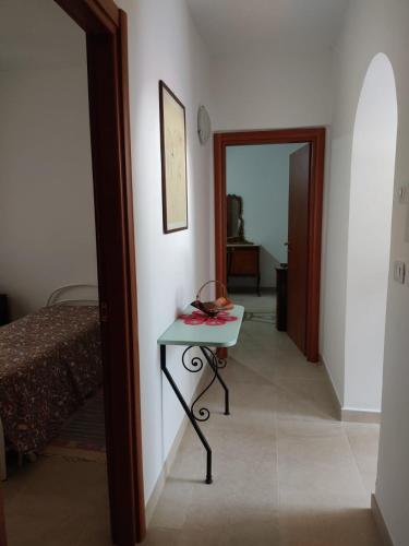 a room with a table and a bed and a hallway at Tra i Parchi in Pescina