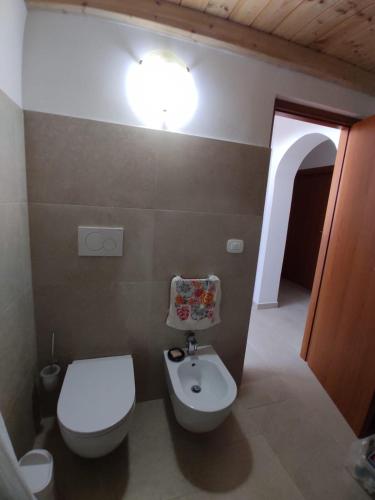 a bathroom with a white toilet and a sink at Tra i Parchi in Pescina