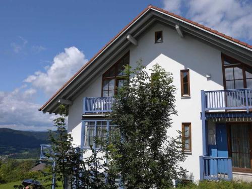 una casa bianca con balconi sul lato di Ferienland Sonnenwald Fewo 46 a Langfurth 