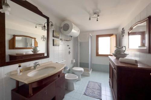 a bathroom with a sink and a toilet and a mirror at [Eleganza Rustica In Villa] A 5 minuti dal mare in Tonnara di Bonagia