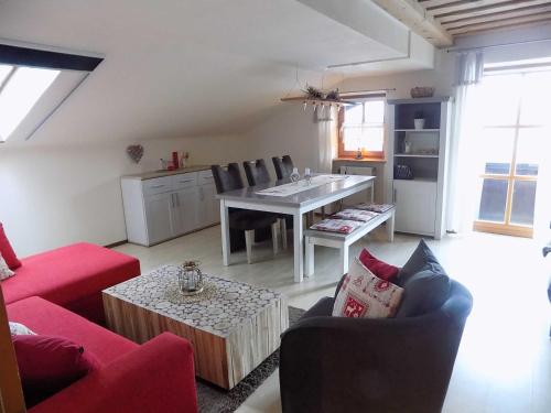 a living room with a red couch and a table at Ferienwohnung Hauzenberg Blick FeWo306 in Hauzenberg