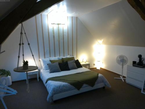 a bedroom with a bed and a table with a lamp at A 2 pas d AZAY in Neuil