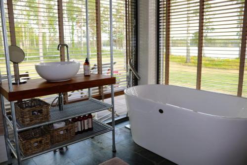 ein Badezimmer mit einer großen Badewanne und einem Waschbecken in der Unterkunft Luxury Lakeside Villa in Katrineholm
