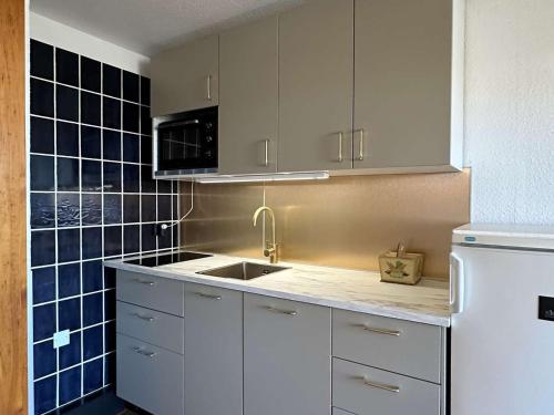 eine Küche mit weißen Schränken, einer Spüle und einem Kühlschrank in der Unterkunft Appartement Port Barcarès, 2 pièces, 4 personnes - FR-1-195-4 in Le Barcarès