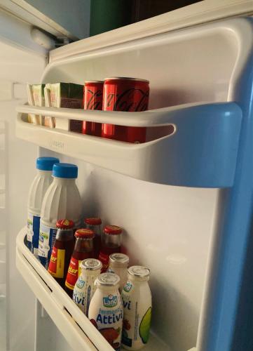 a refrigerator filled with lots of milk and condiments at Residenza Borgo 9 in Collecchio
