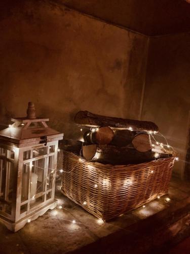 a basket of logs and a lantern with lights at Residenza Borgo 9 in Collecchio