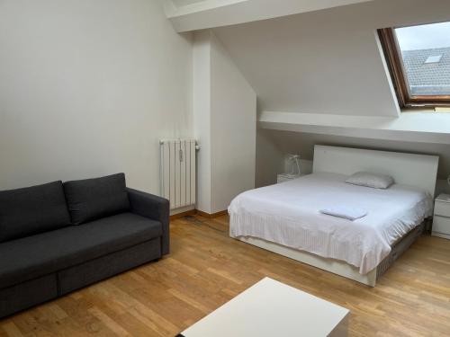 - une chambre avec un lit et un canapé dans l'établissement Uccle Chic Flat, à Bruxelles