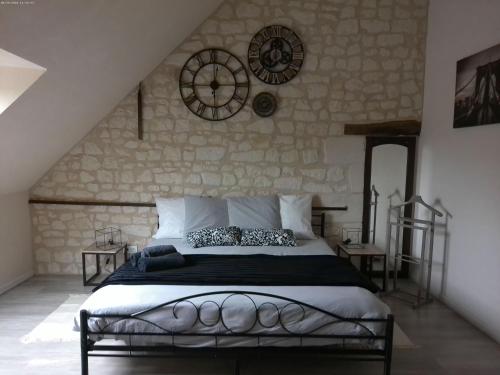 a bedroom with a bed and a stone wall at A 2 pas d AZAY in Neuil