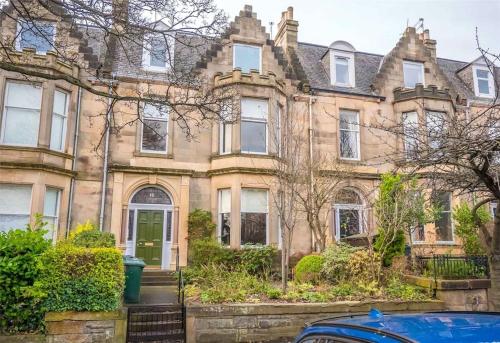 an old house with a car parked in front of it at Beautiful & bright 2 bed flat Murrayfield in Edinburgh