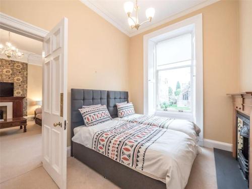 a bedroom with a large bed and a window at Beautiful & bright 2 bed flat Murrayfield in Edinburgh
