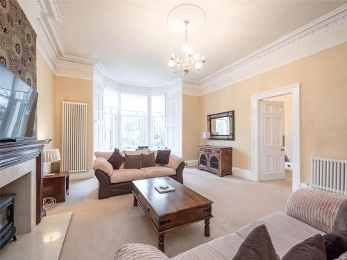 a living room with a couch and a table at Beautiful & bright 2 bed flat Murrayfield in Edinburgh