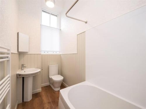 a white bathroom with a sink and a toilet at Beautiful & bright 2 bed flat Murrayfield in Edinburgh
