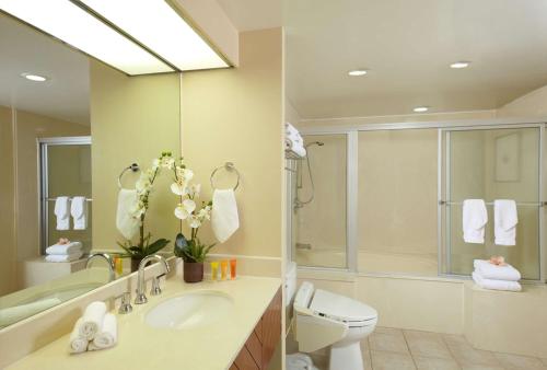 La salle de bains est pourvue d'un lavabo, de toilettes et d'un miroir. dans l'établissement Oasis Hotel Waikiki, à Honolulu