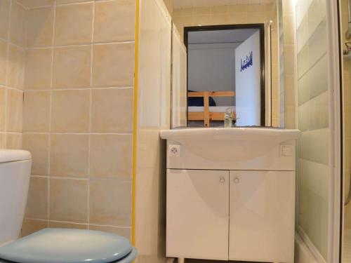 une salle de bain avec un lavabo, des toilettes et un miroir dans l'établissement Appartement RDC 2 pièces+cabine, piscine, terrasse, parking privé - Saint Pierre La Mer - FR-1-229D-71, à Fleury