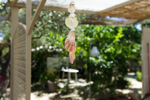 a pair of seashells hanging from a pergola at Garden Rooms in Fanárion